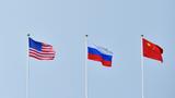 Flags of the United States, Russia, and China in the sky, photo by Pridannikov/Getty Images