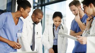 Diverse group of doctors having a discussion around a table, photo by AJ_Watt/Getty Images
