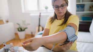 Woman preparing to take her own blood pressure at home, photo by mixetto/Getty Images