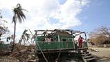 A woman stands on a ruined building after Hurricane Eta, in Wawa Bar, a Miskito indigenous community in Puerto Cabezas, Nicaragua, November 23, 2020, photo by Katlyn Holland/CRS /Latin America News Agency/Reuters