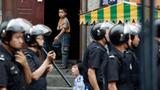 An ethnic Uyghur boy stands at the door of his home as Chinese security forces secure the area in Urumqi, China, July 10, 2009, photo by Nir Elias/Reuters