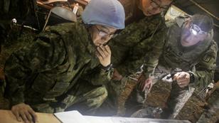 Members of the Japan Ground Self-Defense Force and a U.S. Army captain examine a field artillery safety diagram at Yausubetsu Training Area, Japan, photo by U.S. Army