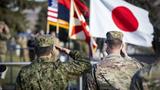 A Japan Ground Self Defense Force soldier (left) and a U.S. Army soldier (right) salute the Japanese and U.S. flags during the opening ceremony of Rising Thunder 2021 at Yakima Training Center, Washington, December 1, 2021, photo by Spc. Dean Johnson/U.S. Army 