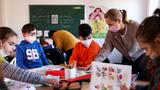Teacher Aleksandra Artemova teaches Ukrainian refugee children during a school preparation course in Dusseldorf, Germany, March 18, 2022, photo by Thilo Schmuelgen/Reuters