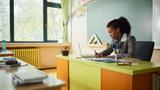A teacher at her desk working on lesson plans, photo by skynesher/Getty Images