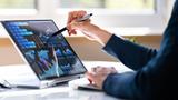 A person is using a stylus and a tablet to access a dashboard showing business analytics.