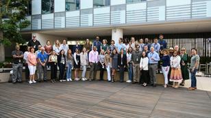 Large group of new hires posing in the courtyard of the Santa Monica Headquarters. 