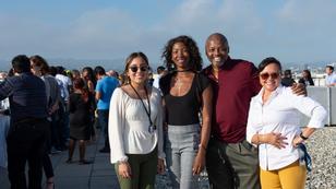 Photo of four RAND employees posing together at a celebration on the roof of the Santa Monica Headquarters. 