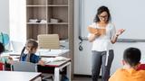 african american teacher reading book to pupils during lesson, photo by LIGHTFIELD STUDIOS/Adobe Stock