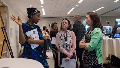 Three employees chatting at a work event.