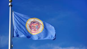 Minnesota state flag against a blue sky, photo by herreid/Getty Images