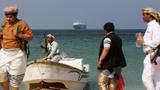 Armed men on the beach with the Galaxy Leader, seized by Yemen's Houthis in November, anchored off the coast of al-Salif, Yemen, December 5, 2023, photo by Khaled Abdullah/Reuters