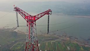 Technicians working at the construction site of the Chongqing section of the Baihetan-Jiangsu ultra-high-voltage UHV power transmission project over the Yangtze River in Chongqing, China, December 5, 2021, photo by IMAGO via Alamy
