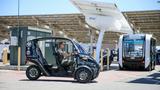 U.S. Marine Corps Sgt. Edwin Diaz, an automotive maintenance technician with Marine Air Control Squadron 1, 3rd Marine Aircraft Wing, drives the Arcimoto electric vehicle in front of the Beam EV ARC charging station and Olli autonomous electric shuttle during the NavalX SoCal Tech Bridge's Electric Mobility Symposium hosted on Marine Corps Air Station Miramar, San Diego, California, June 24, 2021. U.S. Marine Corps photo by Gunnery Sgt. Marcin Platek.