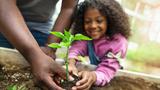 Father and daughter holding small seedling at community garden greenery, photo by FangXiaNuo/Getty Images