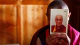 A monk in Gansu Province, China, holds a picture of the Dalai Lama ahead of the Tibetan New Year, February 21, 2012, photo by Carlos Barria/Reuters