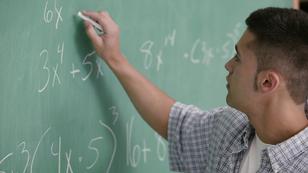 Teen boy solving algebra equations on. chalkboard, photo by Comstock Images/Getty Images
