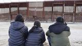 A Chinese family sits in front of a wall on the U.S.-Mexico border in Jacumba Hot Springs, California, January 23, 2024, photo by Kyodo via Reuters Connect