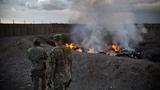 U.S. Army soldiers watch garbage burn in a burn-pit at Forward Operating Base Azzizulah in Maiwand District, Kandahar Province, Afghanistan, February 4, 2013, photo by Andrew Burton/Reuters 