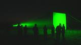 Silhouetted soldiers stand the green glow of a Long Range Ocular Interrupter (LROI) that produces a dazzling or glare effect on a closing target. Photo by Todd Getz/Department of Defense