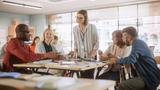 Adult students learning in classroom, working as two teams on a verbal education game. Positive female teacher giving advice, answering questions, and motivating students, photo by gorodenkoff/iStock by Getty Images