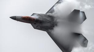 An F-22 Raptor performs an acrobat maneuver that causes dramatic atmospheric effects