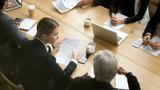 Ariel view of professionals around a conference table, photo by fizkes/Getty Images