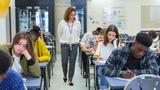 High school teacher supervising students taking exam at desks, photo by Chris Ryan/Caia Image/Adobe Stock