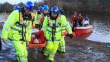 Emergency services workers rescue volunteers posing as flood victims during an exercise on flood response in Surrey, England, November 18, 2010, photo by Luke MacGregor/Reuters