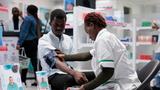 Medic measuring patient blood pressure in a community pharmacy, photo by Dragos Condrea/Adobe Stock.
