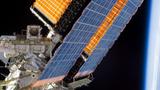 Space appears black and without stars behind an orbital solar panel, photo by NASA