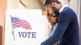 A Black man and Black woman vote in U.S. elections, photo by adamkaz/Getty Images