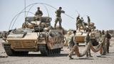 A Warrior armoured fighting vehicle crew prepares to camouflage its wagon in the Oman desert, where UK forces are taking part in a month-long exercise, Saif Sareea 3, October 8, 2018, photo by Ben Birchall/PA Images via Reuters