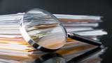 File dtack and magnifying glass, photo by Sezeryadigar/Getty Images