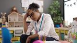 A Kindergarten teacher looking stressed in her classroom, photo by Krakenimages.com/Adobe Stock