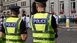 Police officers watching a crowd, photo by Sagar Simkhada/Adobe Stock