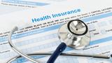 Closeup of a stethoscope on top of a health insurance form, photo by Casper1774Studio/Getty Images