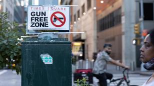 People walk past a sign that reads 'gun free zone' in Times Square as new gun laws are due to come into effect, New York, August 31, 2022, photo by Jeenah Moon/Reuters