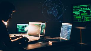 A hacker in a dark room with several laptops and a map of Australia, composite image from South_agency and inkoly/Getty Images