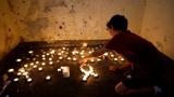 A boy lights memorial candles inside a bomb shelter in which people were killed during the October 7 attack by Hamas, near Kibbutz Mefalsim in southern Israel, October 7, 2024, photo by Amir Cohen/Reuters