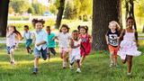 A group of happy diverse boys and girls run in the park, photo by Kalinovskiy/Getty Image