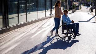 A woman pushing a man in a wheelchair outside, photo by Westend61 GmbH/Alamy Stock Photo
