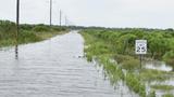 A speed limit sign is visible next to a flooded road, photo by Andrew Kornacki/U.S. Army Corps of Engineers