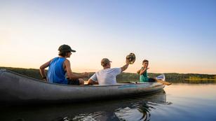 Air Force service member takes his sons canoeing at sunset out on the lake, photo by Scott Thompson/Adobe Stock