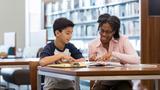 A middle school student and his teacher sitting in a school library, photo by SDI Productions/Getty Images