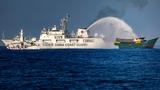 A China Coast Guard ship fires a water cannon at a Philippine Navy chartered vessel in the South China Sea, March 5, 2024, photo by Ezra Acayan/Getty Images