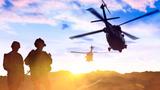 A military helicopter flies over troops on the ground at sunset, photo by guvendemir/Getty Images.