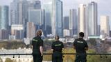 Ambulance workers look out towards the Canary Wharf financial district from Greenwich Park, in London, United Kingdom, October 16, 2024, photo by Mina Kim/Reuters