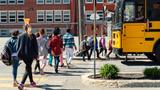 Group of elementary school students crossing the street to get on a school bus, photo by martinedoucet/Getty Images
