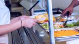 Student waits to be served in a school cafeteria, photo by SDI Productions/Getty Images